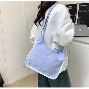 Lavender messenger bag detail showing two front pockets with white contrast trim for books