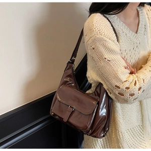 Détail du sac fourre-tout en cuir verni marron foncé avec finition brillante et boucle