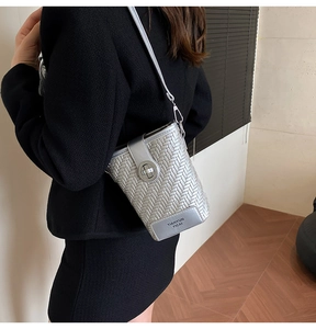 Detail of silver woven crossbody bag with metal twist lock and TIANYUN YICAI brand plate