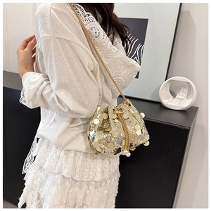 Détail du sac seau à paillettes dorées avec cordon à perles et bandoulière chaîne