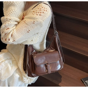 Vue détaillée du grand sac hobo marron foncé avec finition brillante sur escalier bois