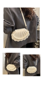 Detail of white shell-shaped shoulder bag with decorative pearl chain and pleated texture