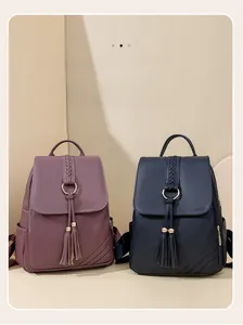 Detail of PU leather backpacks with metal rings and decorative tassels in purple and navy