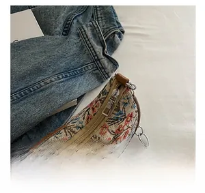 Détail de la fermeture éclair en métal lisse et de la broderie sur le sac tissé