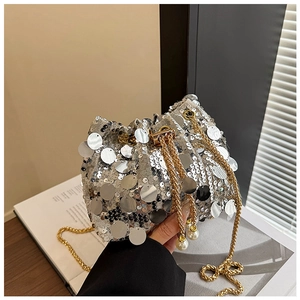 Détail du sac seau à paillettes argentées avec chaîne dorée et breloque en perle