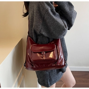 Détail du grand sac cabas bordeaux en cuir verni avec boucle argentée et fini brillant