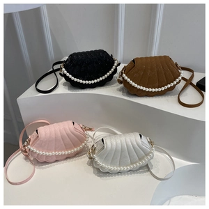 Detail view of four shell-shaped handbags in black, brown, pink, and white textured leather