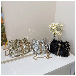 Detail of sequin bucket bags in gold, silver, and black with pearl drawstring accents
