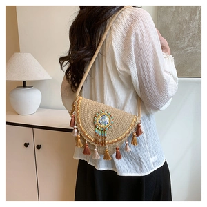 Detail of bohemian straw crossbody bag with colorful tassels and ethnic beaded disc