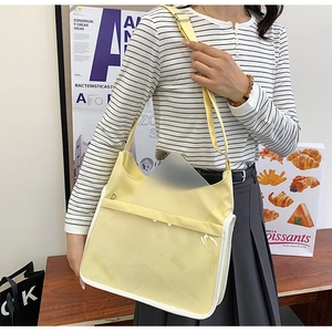 Detail of light yellow messenger bag with large transparent PVC pocket and nylon fabric