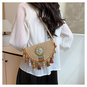 Close-up of woven straw crossbody bag featuring colorful beads and tassels detailing