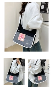 Detail of canvas messenger bag with large transparent PVC display window and white piping