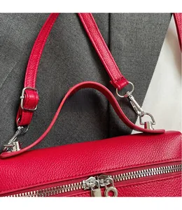 Dettaglio borsa in pelle martellata rossa con cerniera argentata e fibbia metallica