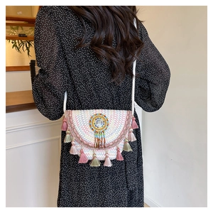 Detail of bohemian woven crossbody bag featuring colorful wave patterns and fringe tassels