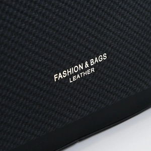 Macro detail of high-quality black leather texture with silver Fashion & Bags engraving