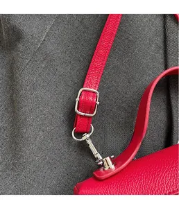 Dettaglio della borsa in pelle martellata rossa con fibbia argento e tracolla regolabile