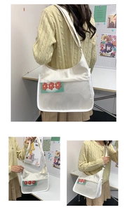 Close-up of white messenger bag featuring a transparent front pocket with floral insert