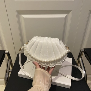Chic white shell crossbody bag with snake pattern texture and elegant pearl handle strap