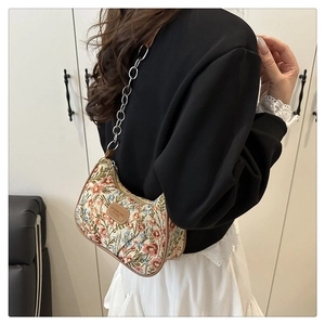 Détail de la broderie florale et de la chaîne métallique sur le sac bandoulière