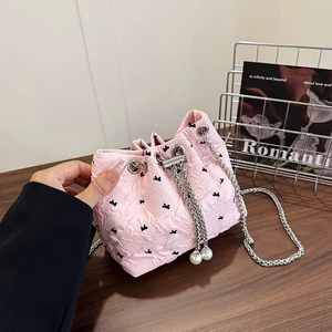 Pink quilted bucket bag with black butterfly embroidery and silver chain strap