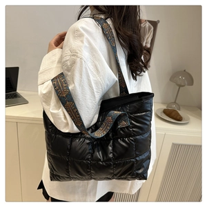 Close-up of quilted down tote bag with vintage embroidery shoulder strap