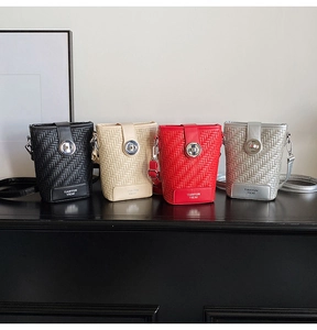 Detail view of woven leather mini bucket bags in four colors with gold metal locks