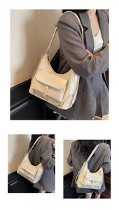 Détail d'un sac à bandoulière blanc crème brillant avec poche avant à rabat chic