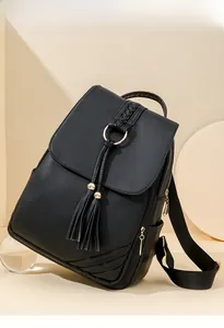 Detail of black PU leather backpack with lychee grain texture and metal ring tassel