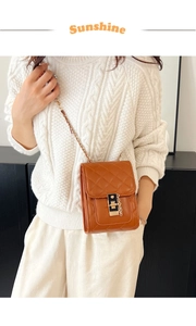 Detail of caramel rhombic quilted leather phone bag with gold chain and metal buckle
