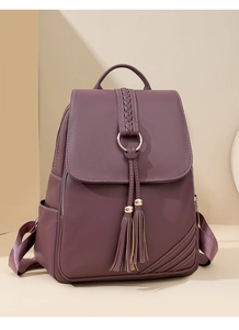 Detail of mulberry purple PU backpack featuring woven handle and gold ring with tassels