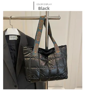 Close-up of black quilted puffer tote bag with colorful ethnic patterned jacquard strap