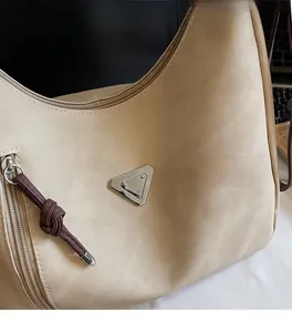 Close-up of beige canvas tote with metal triangle plate and brown braided zipper detail