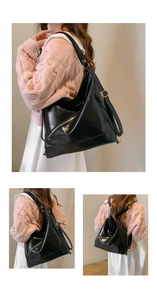 Close-up of black glossy leather tote bag with functional silver decorative zippers