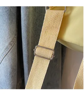 Detail eines verstellbaren hellgelben Web-Schultergurts mit Metall-Schnalle am Rucksack