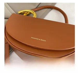 Nahaufnahme der braunen Leder-Satteltasche mit goldenem Logo und Beschlägen