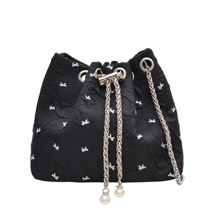 Chic black bucket bag with white bow pattern, metal chain and elegant pearl pendant