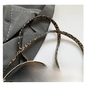 Macro shot of stylish leopard print shoulder strap with gold metal buckle detail