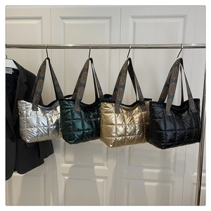 Close-up of quilted space cotton tote bags in silver, gold, green and black with woven straps