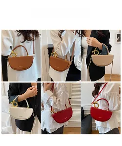 Details modischer Satteltaschen in verschiedenen Farben mit goldenen Metallringgriffen