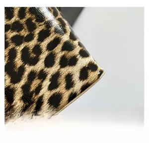 Detailed macro view of glossy patent leather material with leopard print pattern texture