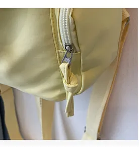 Detail eines silbernen Metallreißverschlusses am gelben Rucksack aus leichtem Nylon