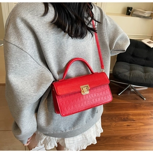 Red crocodile pattern square crossbody bag with gold lock shown on model's back