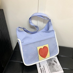 Blue canvas messenger ita bag with transparent PVC window for display on leather bench