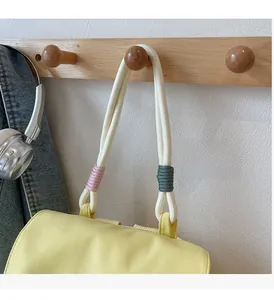Nahaufnahme gelber Rucksack mit dekorativen Seilgriffen und farbigen Nahtdetails