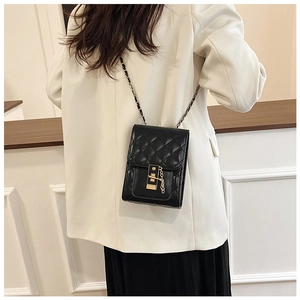 Close-up of black quilted leather shoulder bag featuring gold chain and square lock