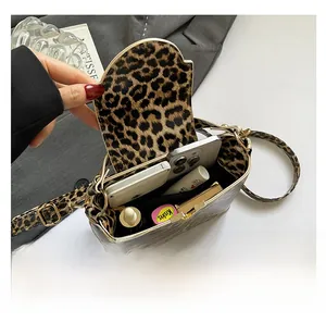 Spacious interior of a leopard print shoulder bag showing phone and cosmetics storage