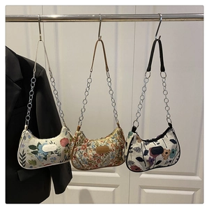 Détail de trois sacs hobo avec broderies florales colorées et bandoulières en chaîne métal