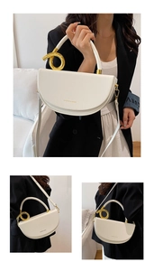 Detail der weißen Satteltasche mit goldenen Metallringen und verstellbarem Schultergurt