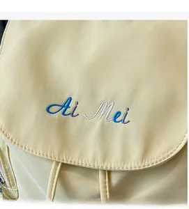 Macro shot of delicate Ai Mei embroidery and fabric texture on yellow backpack