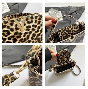 Detail view of leopard print handbag with golden V-buckle and inner zip pocket
